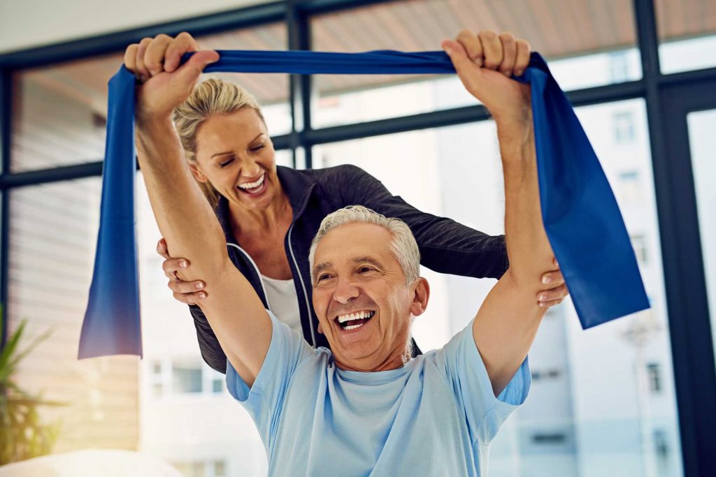 Female trainer assisting Senior in GYM